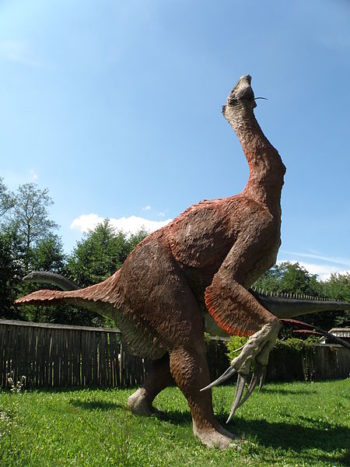 A massive feathered dinosaur with a long neck and exceptionally long claws. The claws are about the same length (or longer) than the dinosaurs hands.