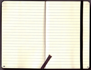 Photo of an open moleskin journal, showing two blank lined pages