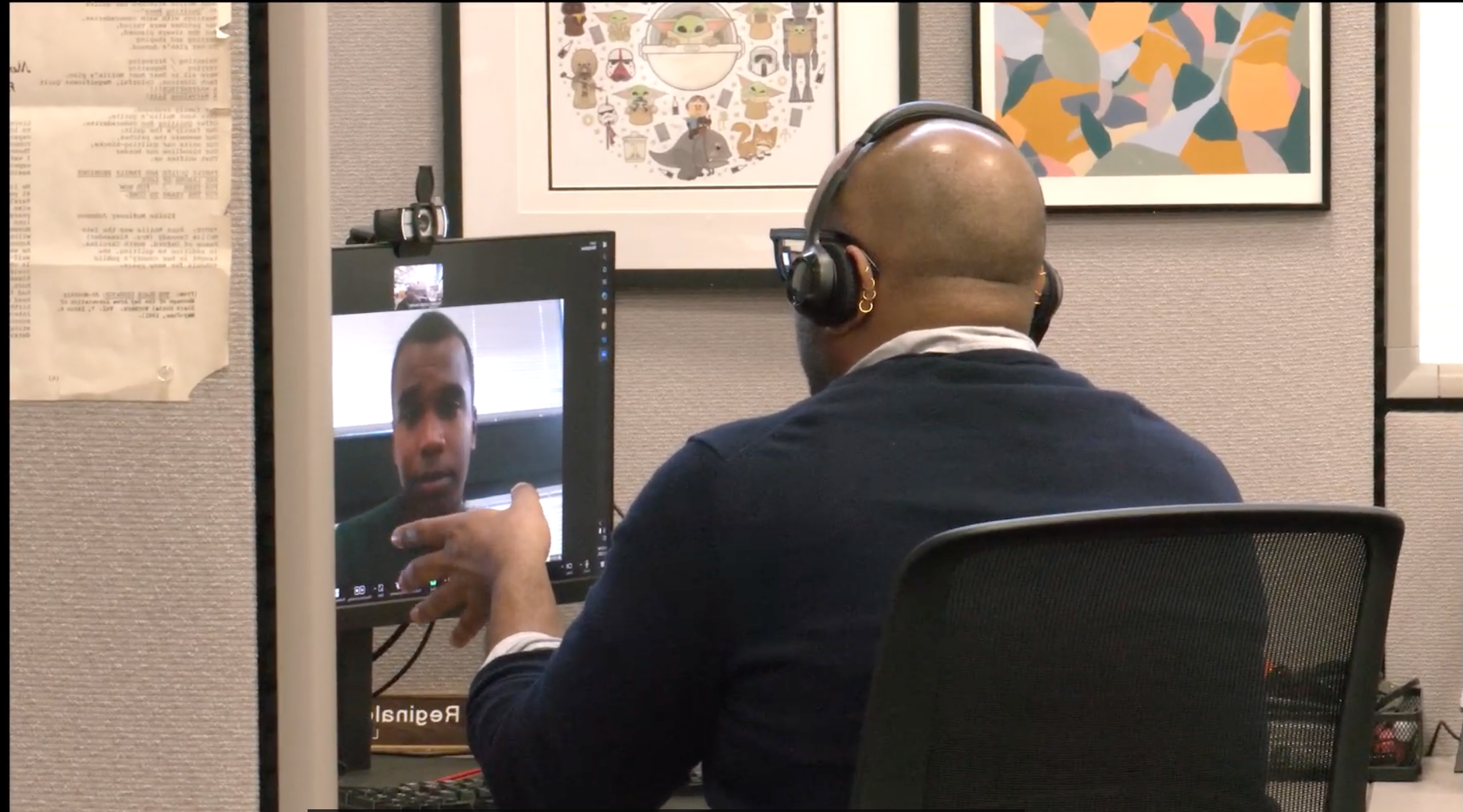 Man looking at a computer screen, how the audience sees an over-the-shoulder shot.