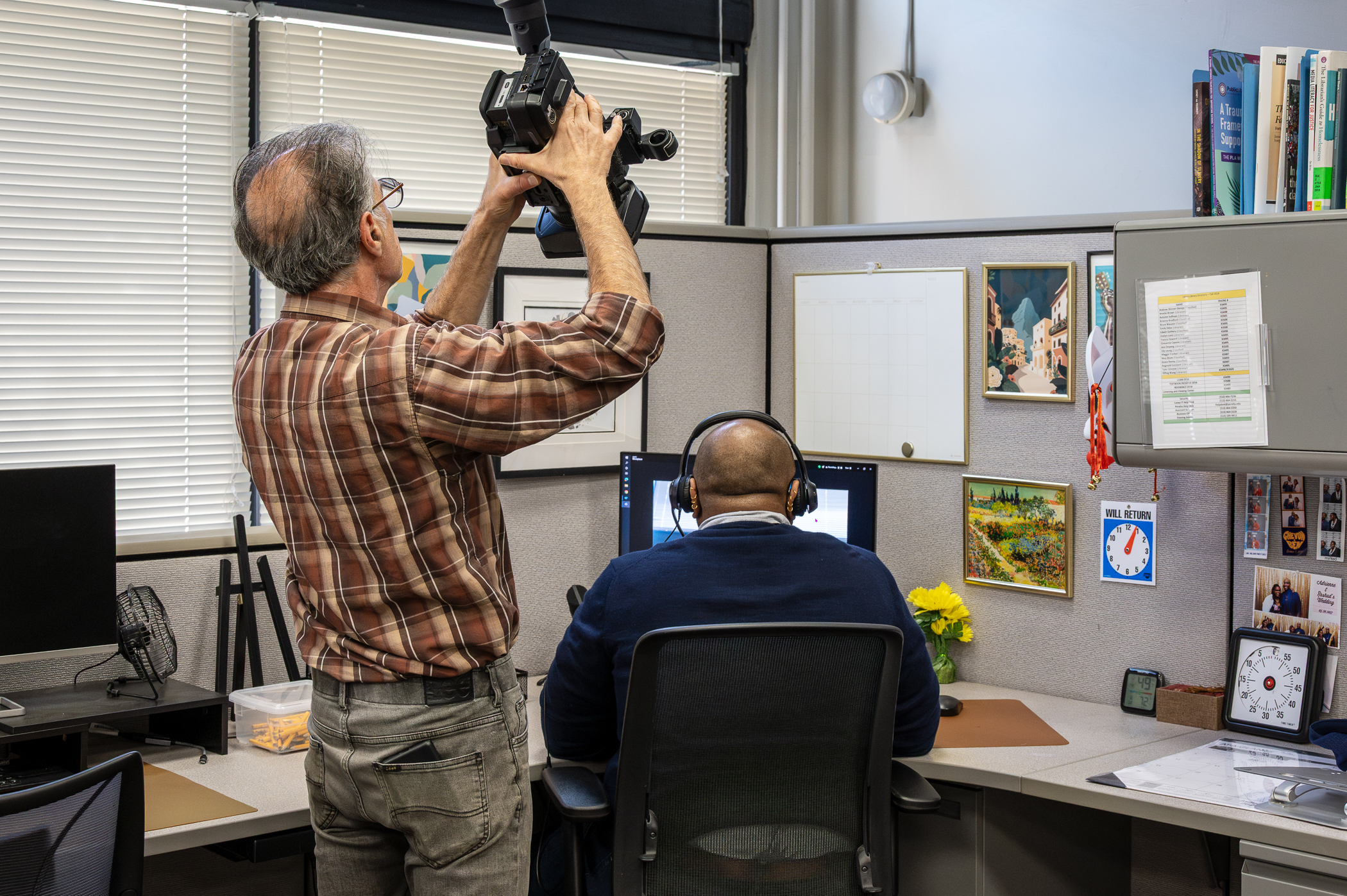 Filming an over the shoulder shot of a man looking a computer screen