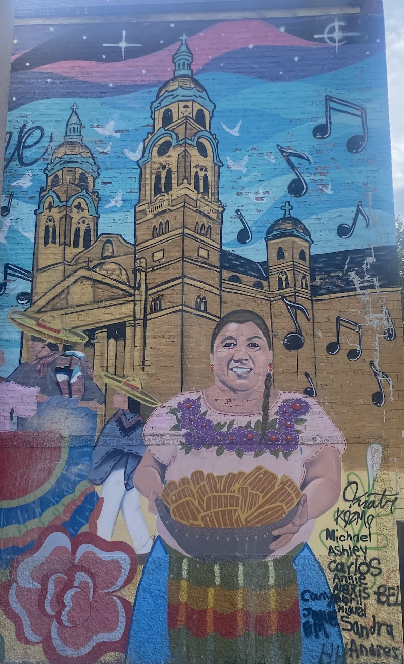 mural de Chicago con una se&ntilde;ora con un canasto de tamales en frente de una iglesia. 
