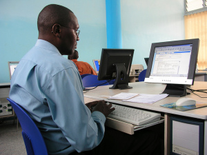 Photo of a man using a computer in an internet cafe