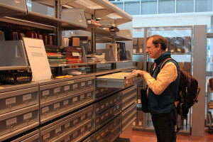 Photo of a man using a card catalog in a library