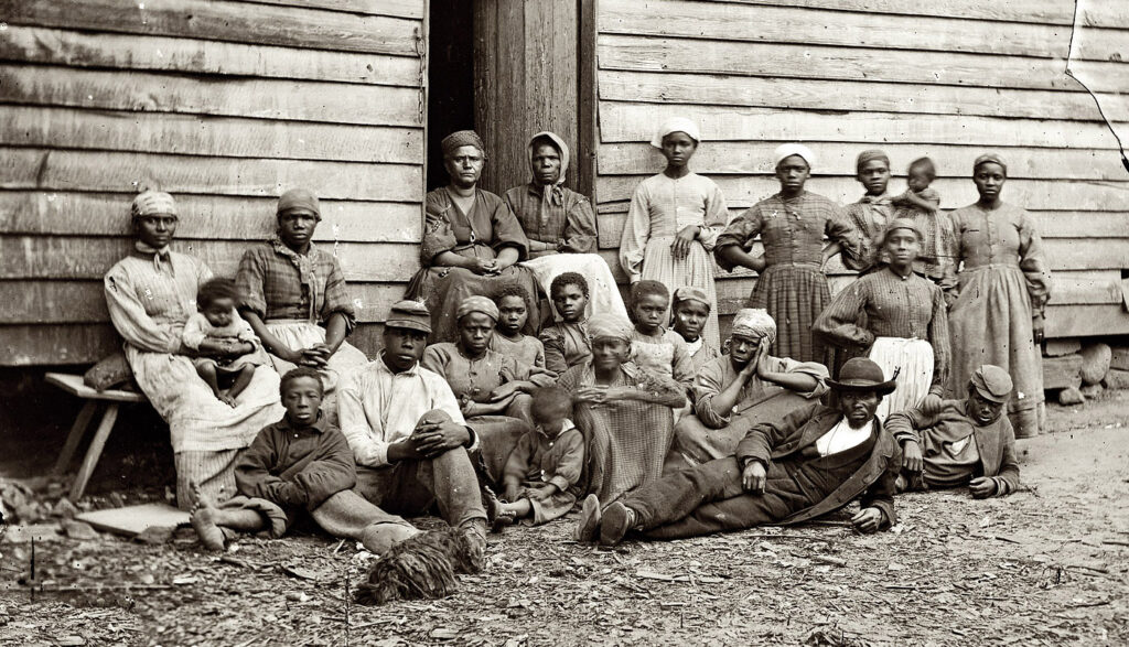 &ldquo;Contrabands,&rdquo; Cumberland Landing, Virginia, 1862. Library of Congress. Photograph of over a dozen African Americans sitting or standing in front of a cabin. They range in age from children to the elderly. 