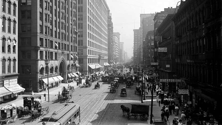 A wide, crowded street amid skyscrapers.