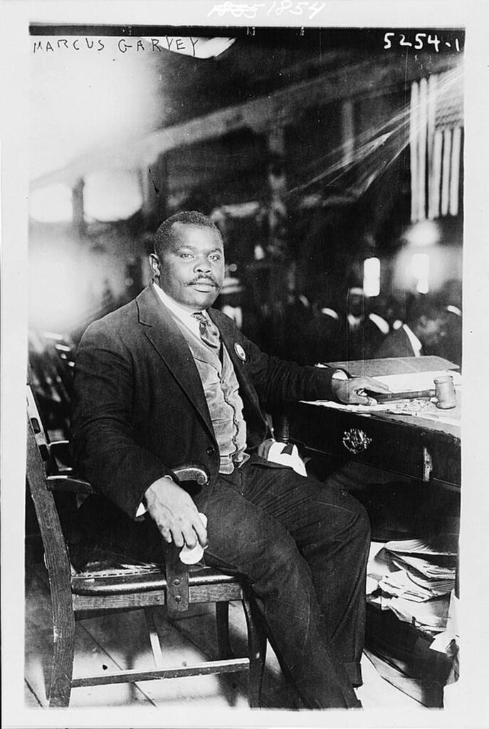 A man wearing a suit sits at a desk.