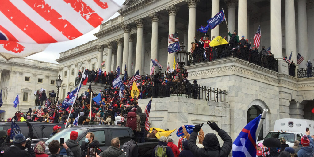 A jubilant crowd stands around the U.S. Capitol Building.