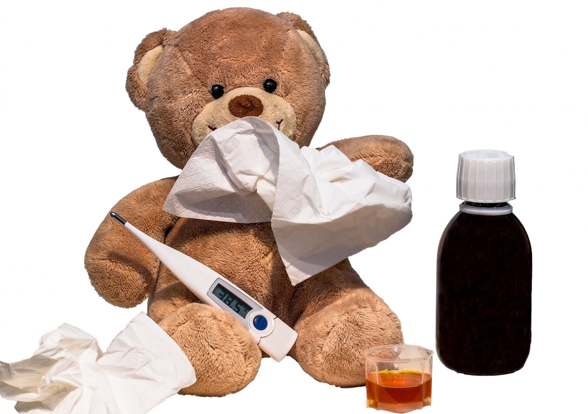 Teddy bear with a tissue on his nose surrounded by medication