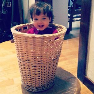 Child in a laundry hamper