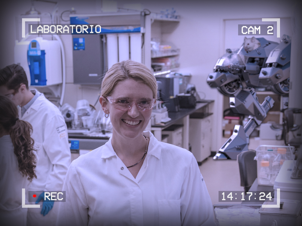 Photo of a smiling scientist in a lab. Behind her, a battle mech is coming through the doorway piloted by a white mouse. The text around the outside of the image reads: Laboratorio, Cam 2, 14:17:24, Recording