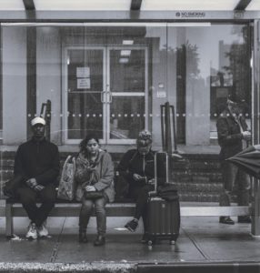 several people waiting at a bus stop