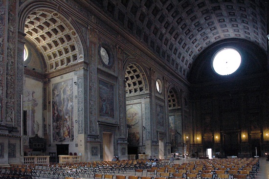 The interior of the nave. The barrel arch is used both in the ceiling and in the aisle alcoves.The walls are covered in intricate paneling and frescos.