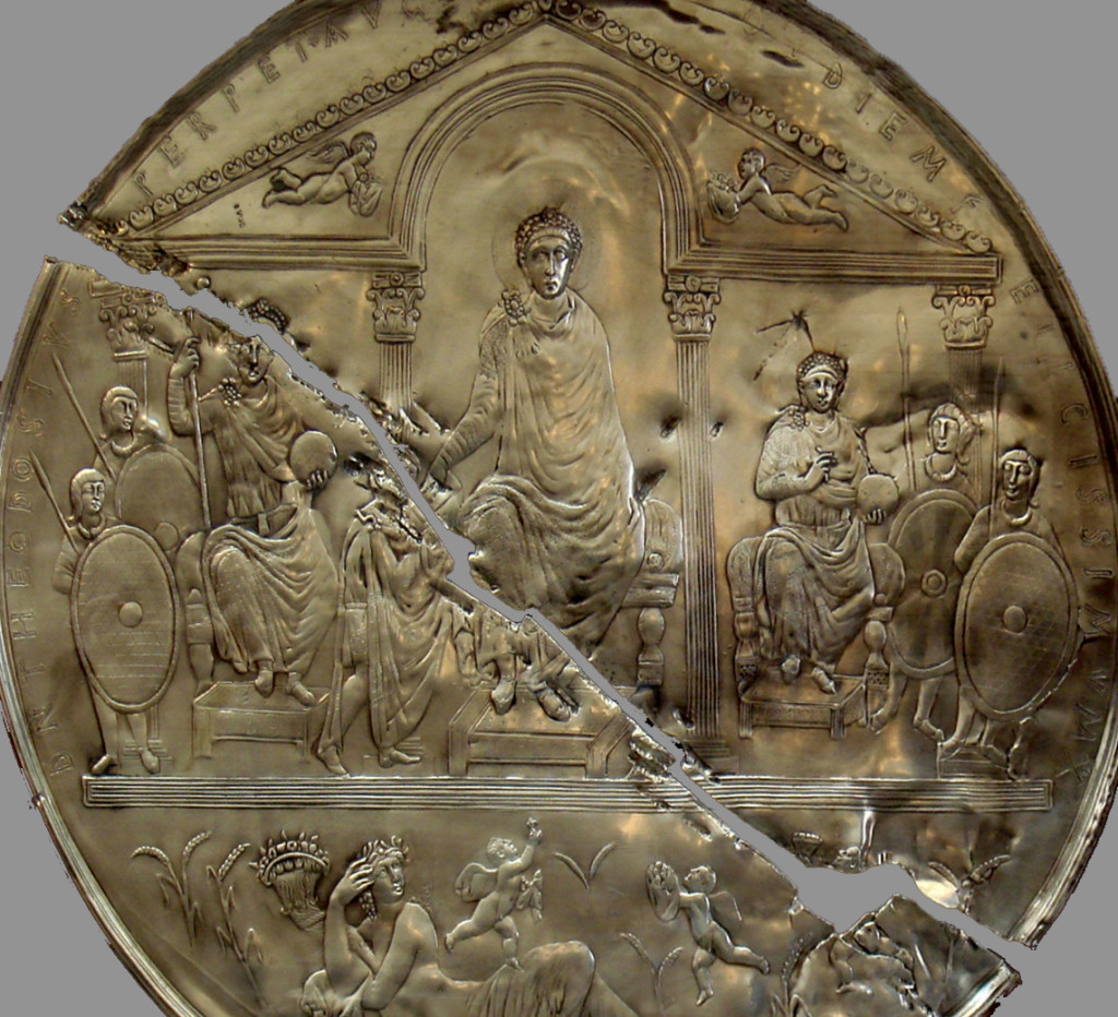 Modern replica of the Missorium of Theodosius (detail) in the Museum of Mérida, Spain. The missorium is broken in two parts, and the replica is as well. The disc features a regal Figure in the middle who appears to be bestowing authority on a person kneeling before him.