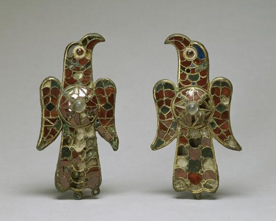 Estas fíbulas tienen forma de águilas con escudo o emblema solar en la espalda
