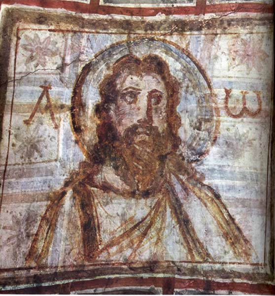 Typical painting of Christ with brown curled hair and a beard. He has a halo behind his head.