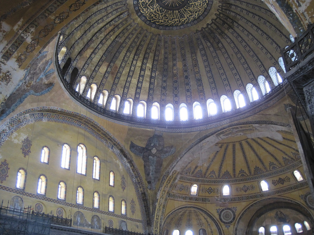 The base of the dome is ringed with windows. There are very narrow borders between each window. Below and behind the main dome, there is a semi dome, which has windows ringing its bottom, but they are much further spaced apart.