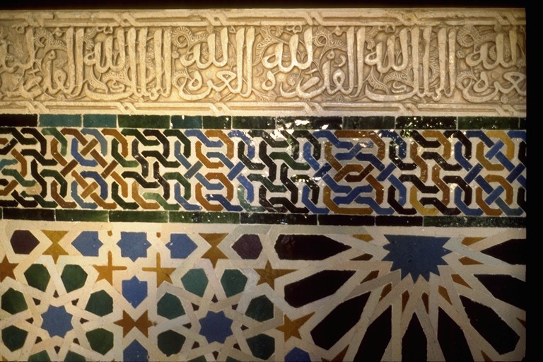El muro se divide en tres porciones horizontales. La parte superior tiene letras árabes, el medio tiene un patrón de nudo geométrico, mientras que la parte inferior tiene un estampado geométrico, casi floral.