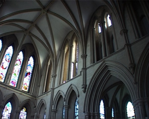 The outside of the aisle is divided from the nave with a wall with pointed arches cutting out entries. The ambulatory's walls have stained glass windows in the shape of pointed arches.