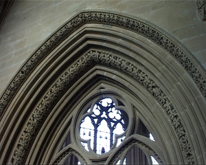 The pointed arch is framed with several layers of carving, all in the same pointed arch shape. The first and last layer have an intricate pattern carved into them.