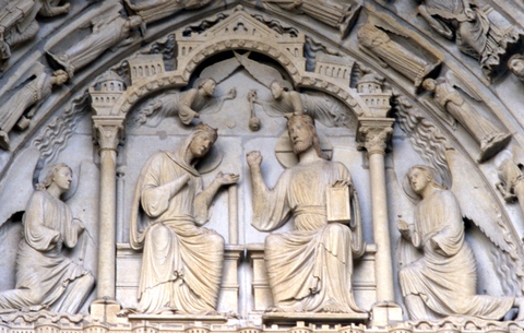 Mary and Christ both enthroned with two angels flying above them while two kneel next to them. Above the tympanum are rows of angels.