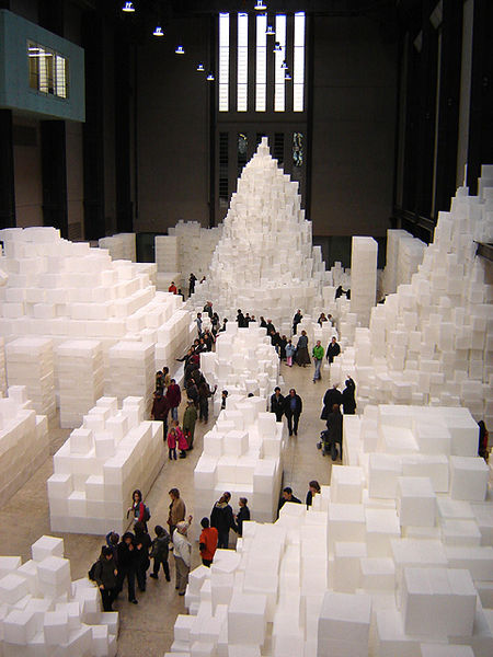 Fotografía de instalación de arte, la cual consta de 14,000 cajas de polietileno translúcidas, blancas apiladas a diferentes alturas.