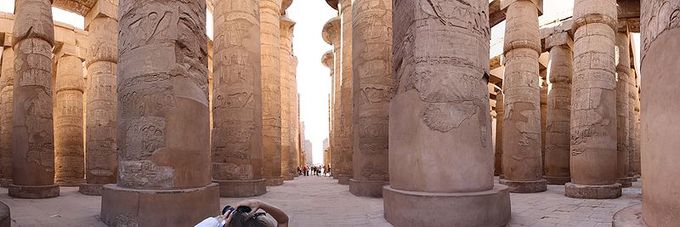 Panoramic photo depicts the ruins of the great hypostyle hall. The roof, now fallen, was supported by 134 columns in 16 rows; the 2 middle rows are higher. The photograph shows several of rows of the columns.