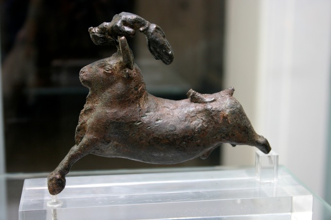 Color photograph of a sculpture depicting an acrobat atop a leaping bull.
