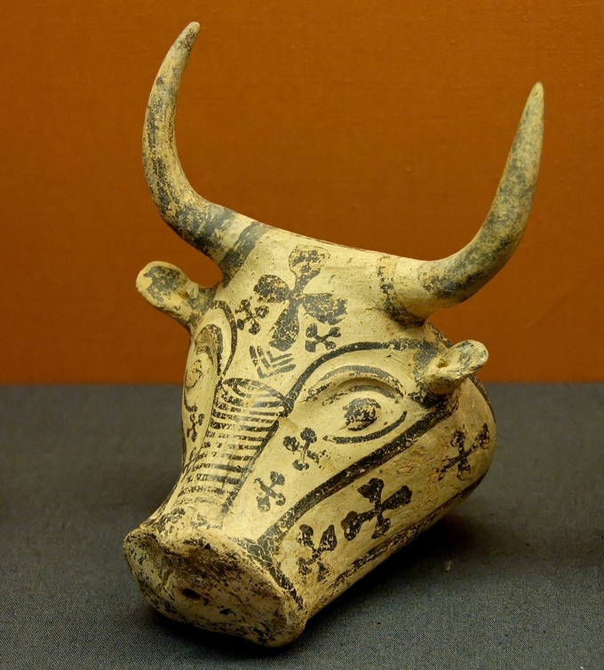 Color photo depicts a rhyton (conical drinking container) in the shape of a bull's head, complete with horns.