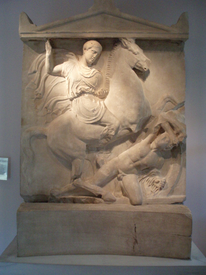 This is a photo of the Grave Stele of Dexileos, it depicts Dexileos on his horse, right arm raised his spear bears down on his enemy (who has a hole bored in his neck).