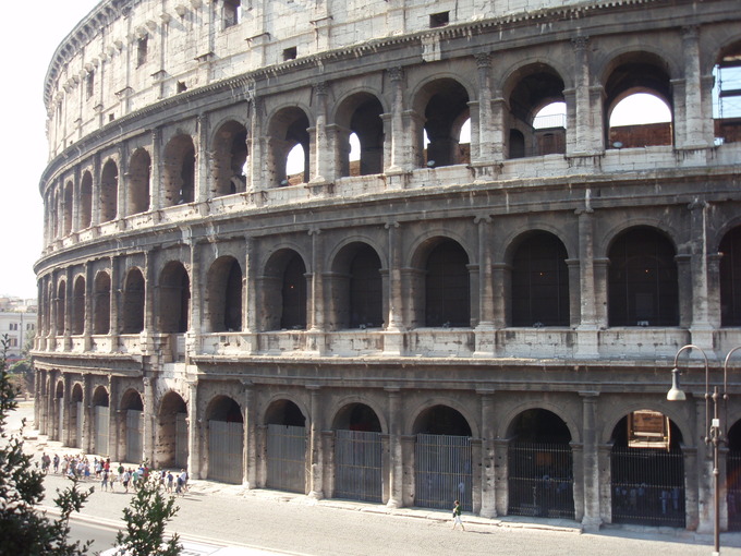 This photo shows the exterior of the Flavian Amphitheater or Colosseum, an oval amphitheatre in the centre of the city of Rome.