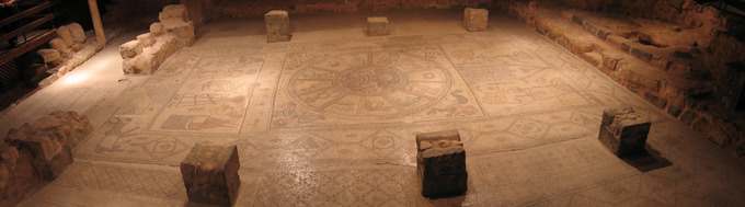 Esta es una foto panorámica de los mosaicos de la nave en Beth Alva. Se muestran tres paneles. El panel izquierdo representa la encuadernación de Isaac. El panel central representa un círculo zodiacal. El panel derecho representa una escena de sinagoga.