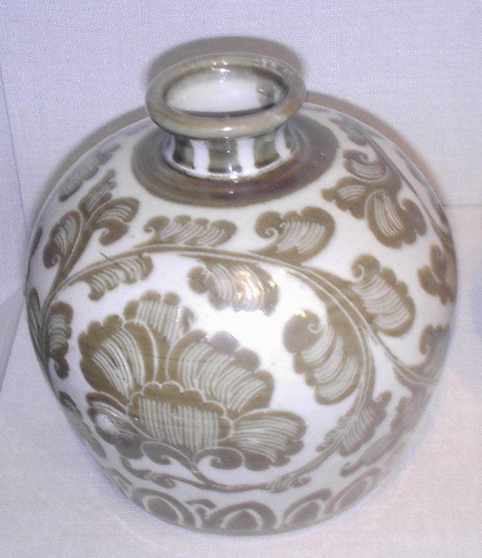 A porcelain bottle with branch and leaf-like decorations.