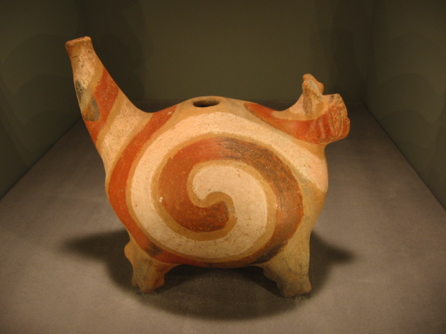 This jug resembles a panther-like animal with a large orange swirl design on the side.