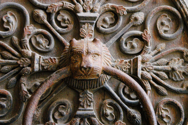 Close up of elaborate door knocker featuring a lion's head.