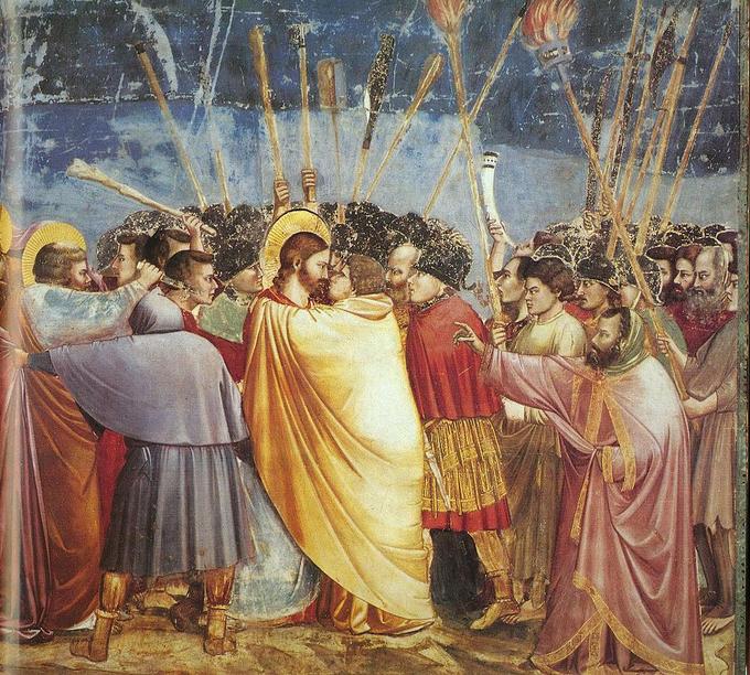 Judas is shown kissing Jesus in the center with many men around them in motion.