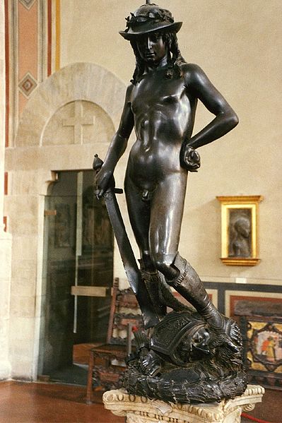 The bronze statue depicts David with an enigmatic smile, posed with his foot on Goliath's severed head just after defeating the giant. The youth is completely naked, apart from a laurel-topped hat and boots, bearing the sword of Goliath.