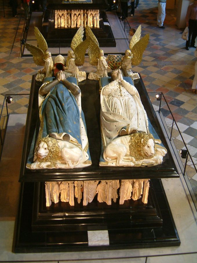 La tumba representa a Juan el Audaz y Margarita de Baviera con las manos juntas, como si rezaran. Los ángeles se arrodillan ante sus cabezas y los leones yacen a sus pies.