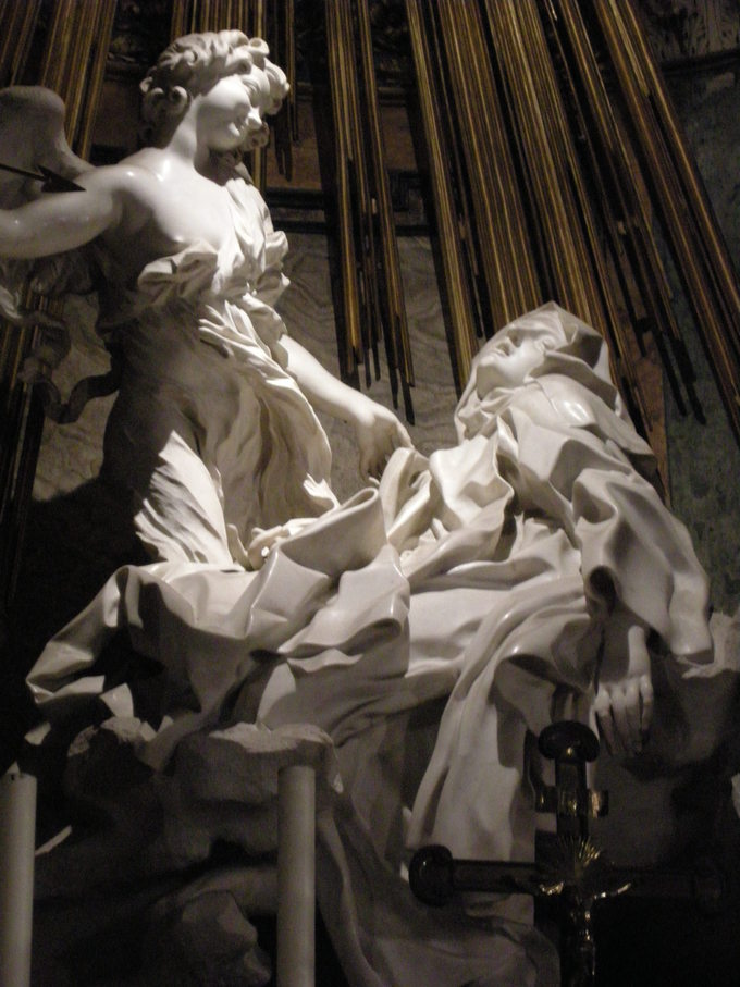 The sculpture depicts two figures: an angel looking down at a nun.