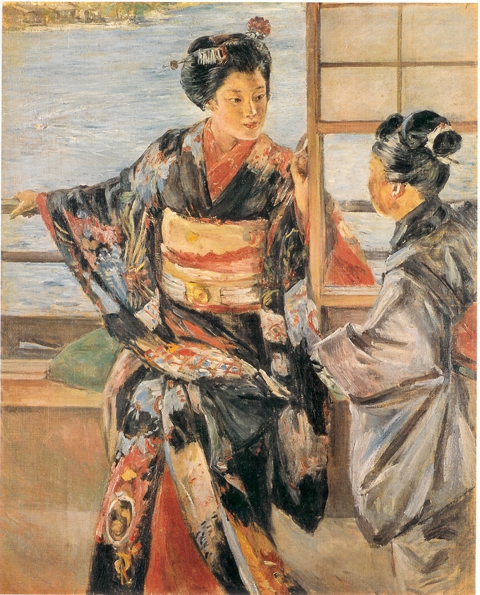 Dos mujeres con atuendos tradicionales se sientan y platican.