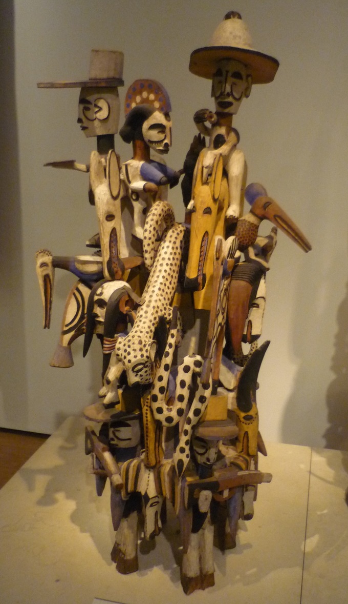 A wooden carving incorporating many different figures and images, such as horsemen, military insignia, and wild beasts.