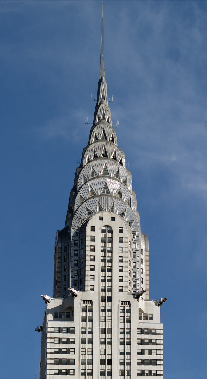 The spire is composed of seven radiating terraced arches, mounted up one behind another. The cladding is ribbed and riveted in a radiating sunburst pattern with many triangular vaulted windows.