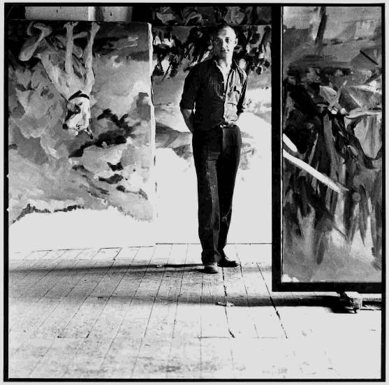 Una foto de Georg Baselitz de pie entre su arte.