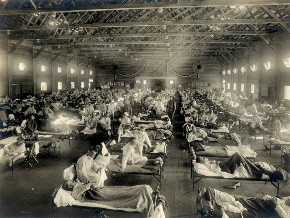 Photo of a large warehouse with rows of beds filled with influenza patients.