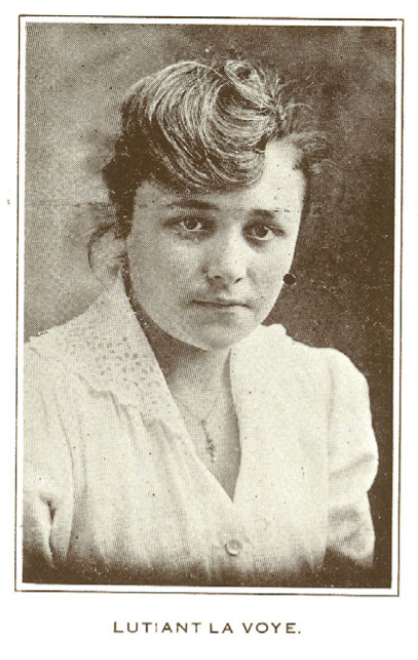 Graduation photo of a young woman in a white dress and a serious expression.