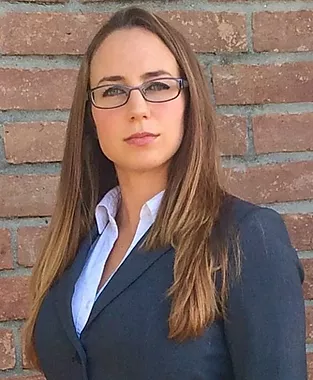 Heather Ringo wearing gray suit against brick background