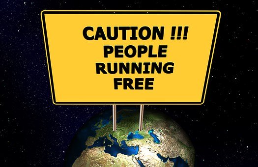 Earth with yellow sign posted that reads "Caution!!! People running free"