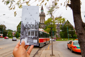 Photograph of a hand holding a vintage photo of a streetcar, lined up with the contemporary shot of the same location with streetcar in present day