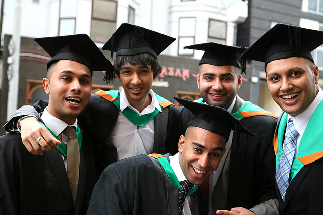 Five young men in graduation gowns.