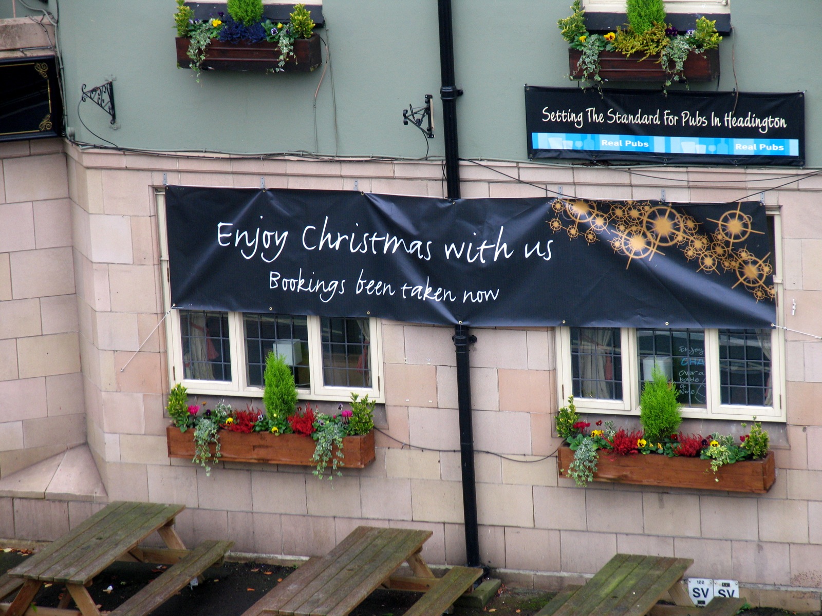 Photo of a small cafe with a banner that reads,"Enjoy Christmas with us. Bookings been taken now."