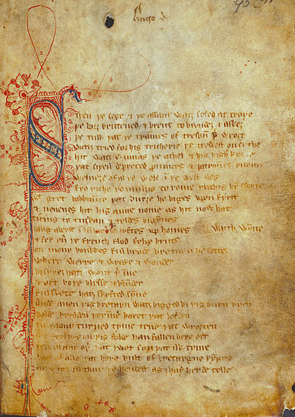 Photo of a fragile paper manuscript page. The writing is in calligraphy, in Middle English, with a large ornate "S" in blue and red ink as the first letter of the text.
